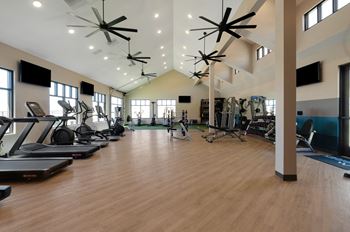 A spacious gym with treadmills, exercise bikes, and other equipment.